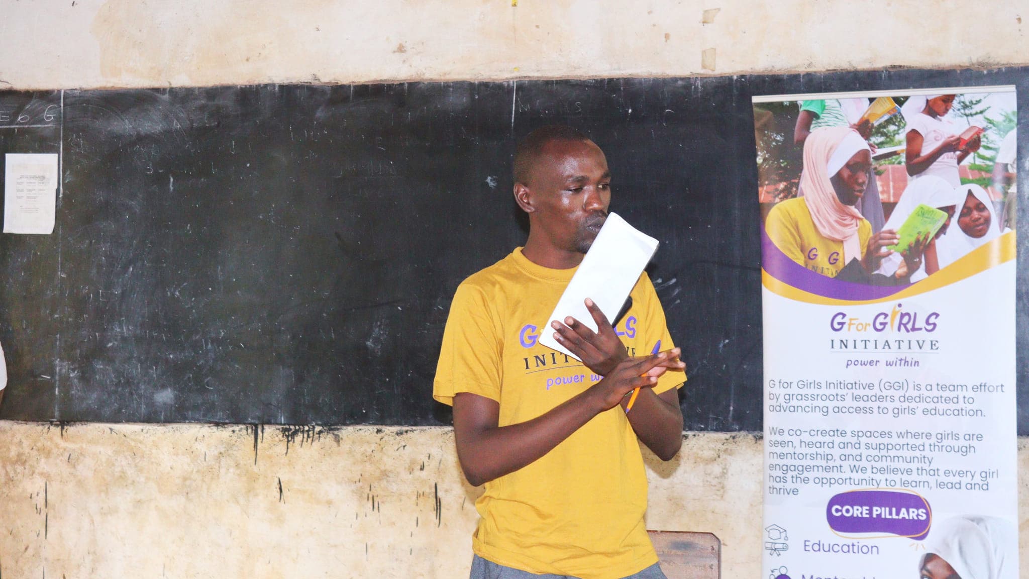 Pius Ntinya, finance officer, talking with Grade 7 girls during pad distribution